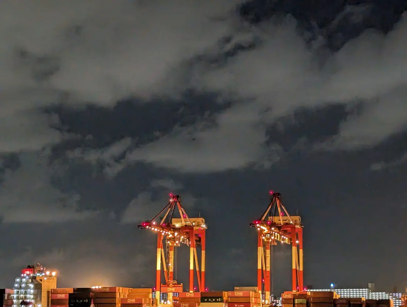 Container terminal cranes lit at dusk